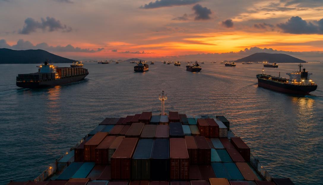 Dense merchant ship traffic in the Strait of Malacca viewed from a high bridge at dusk.